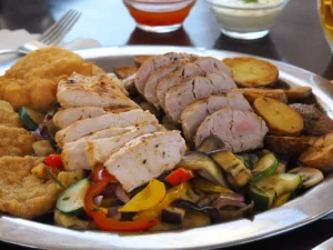 Talíř masa, přílohy a omáčky v moderní sklepní restauraci