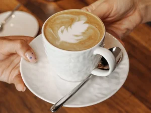 Káva či horká čokoláda a sladký zákusek v kavárně