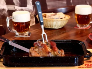 1 či 2 pomalu pečená kolena, chléb, hořčice a křen i pivo Pilsner Urquell