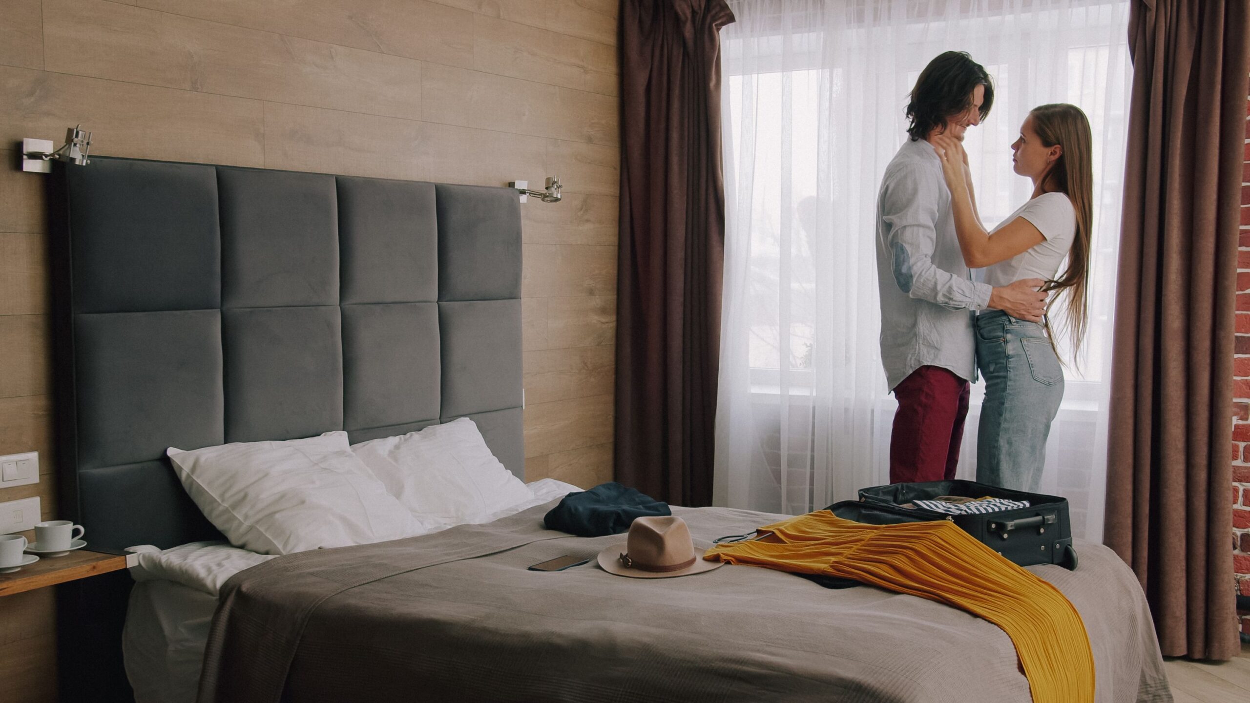 Romanticky pobyt pro dva - objimajici se par v hotelovem pokoji